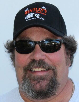Smiling man wearing sunglasses and a Bentley's Saloon cap from Arundel, Maine.