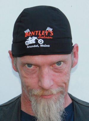 Man with a white beard wearing a Bentley's Saloon cap from Arundel, Maine.