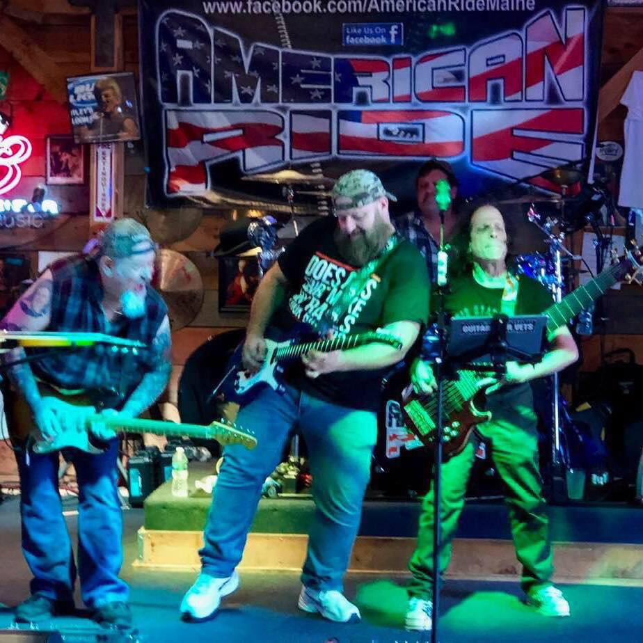A lively band called American Ride performing on stage with guitars and drums.