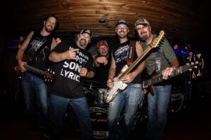 A lively rock band posing with instruments and enthusiasm.