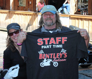Man holding a staff t-shirt at Bentley's Saloon.