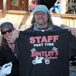 Man holding a staff t-shirt at Bentley's Saloon.